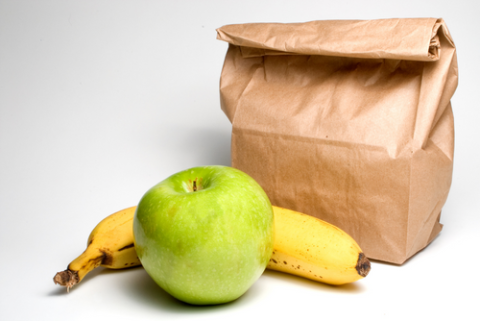 Photo of a sack lunch with apple and banana.